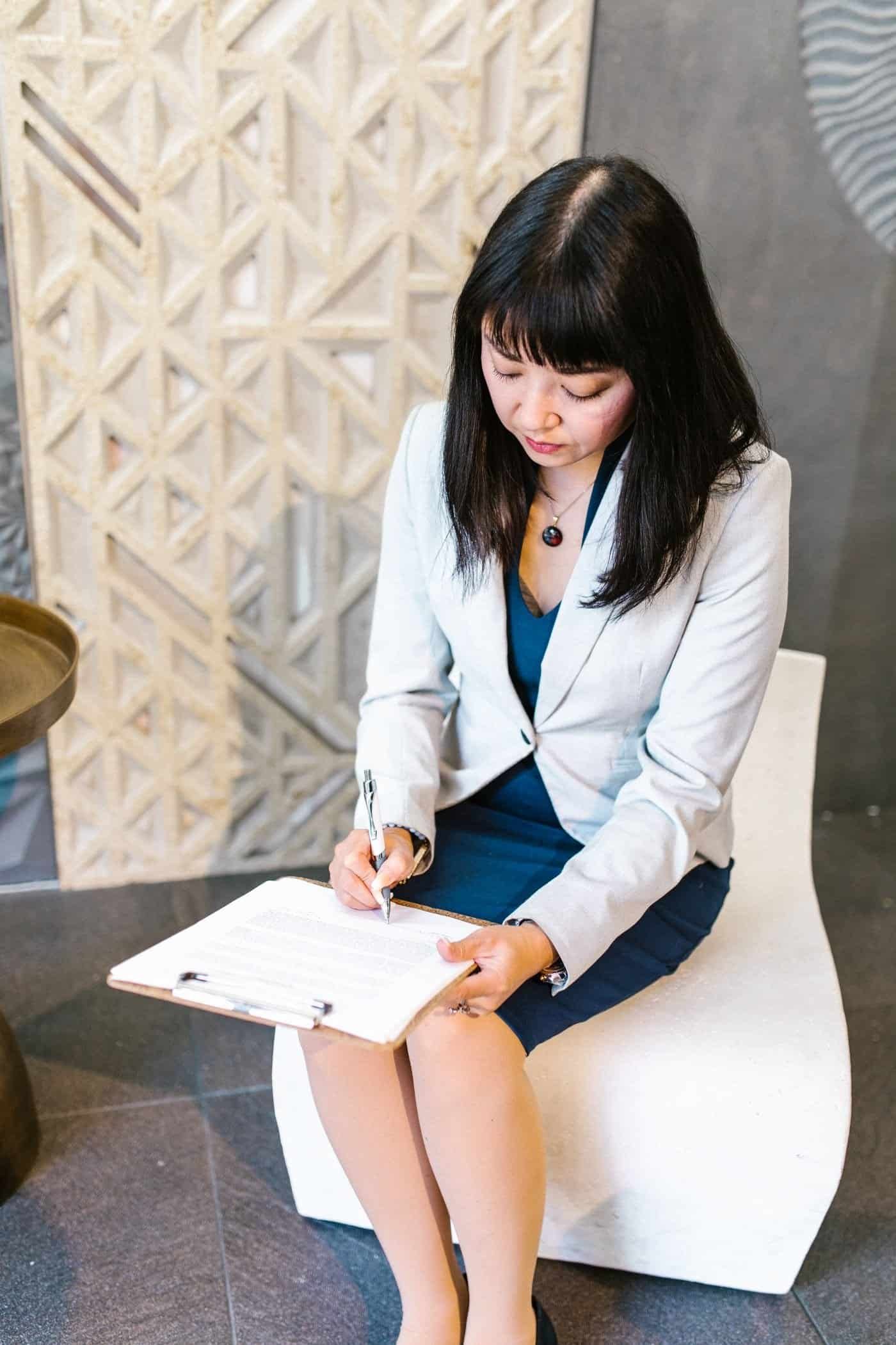 Asian businesswoman in Singapore office signing an employment contract