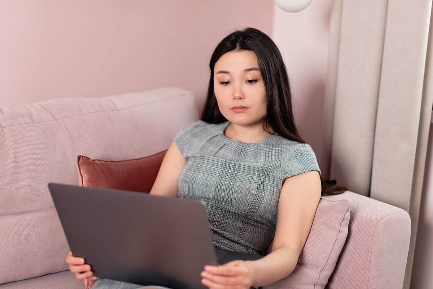 Asian professional woman working remotely on a laptop, freelance context