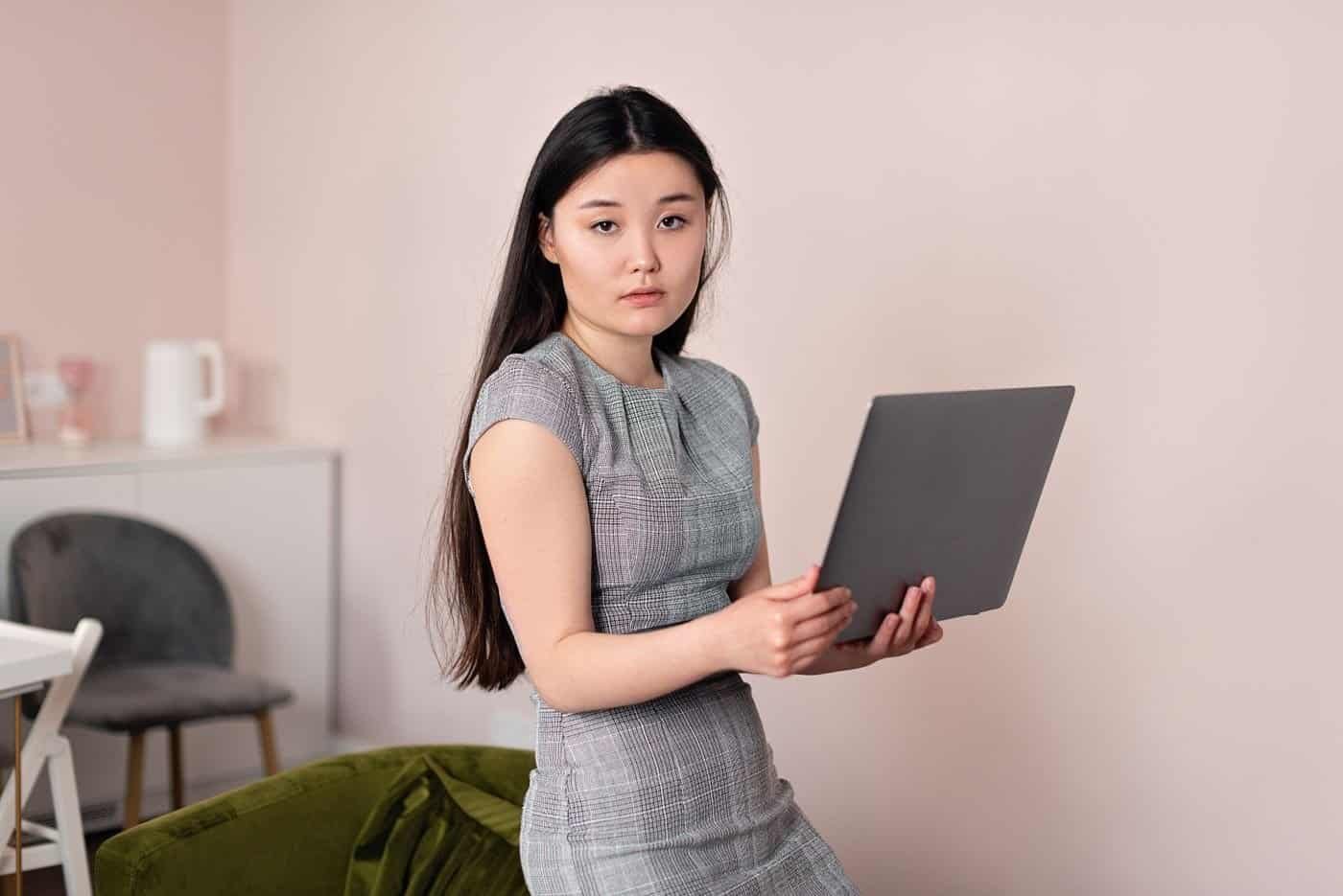 Asian professional woman holding a laptop, representing a foreign professional at work