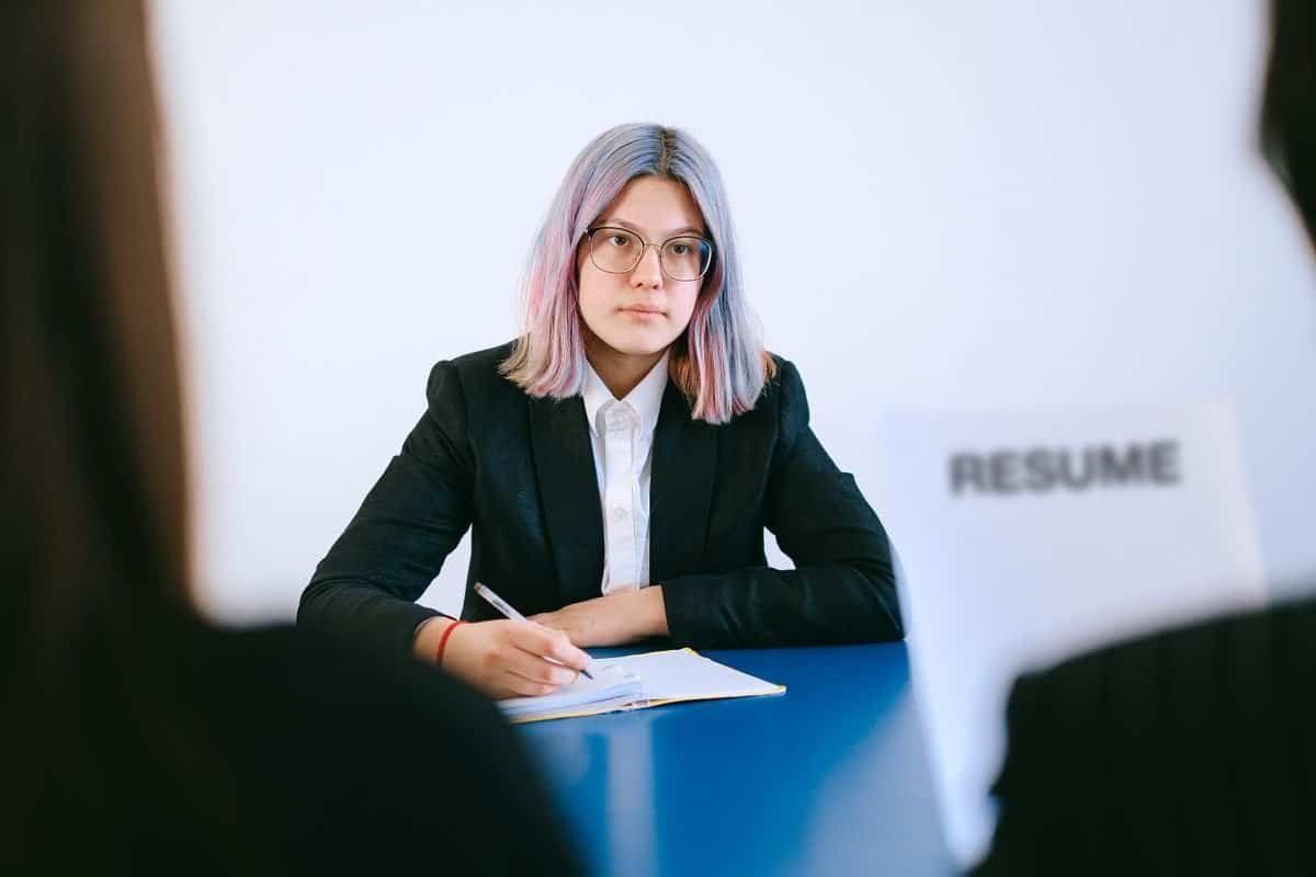 Asian woman being interviewed across a desk in a hiring context, representing fair hiring practices under the Workplace Fairness Act