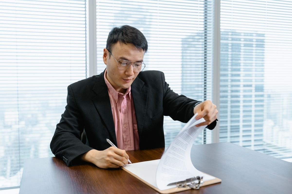Employer signing an employment contract in a Singapore office
