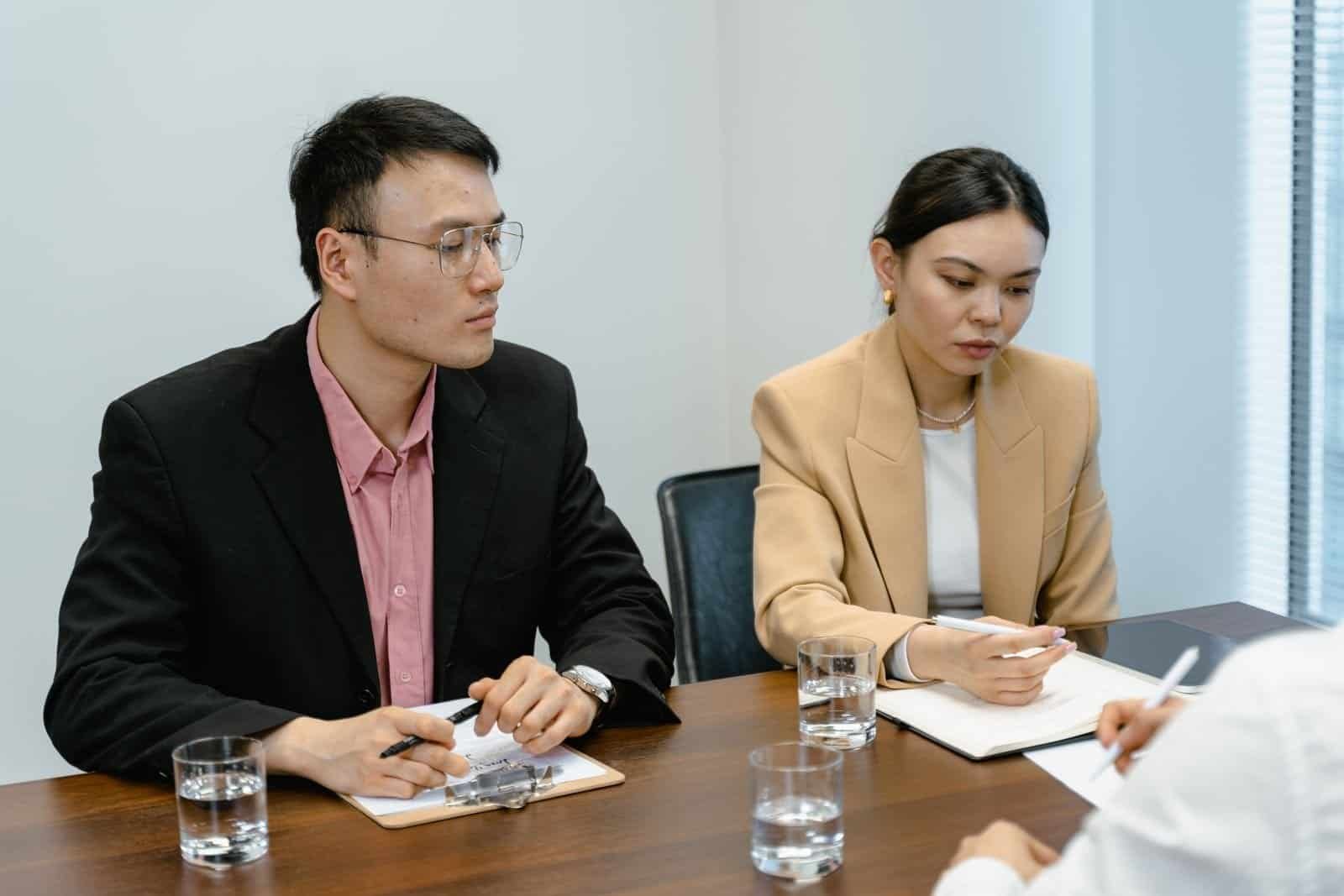 Employer and HR professional discussing Employment Pass and COMPASS eligibility in a Singapore office