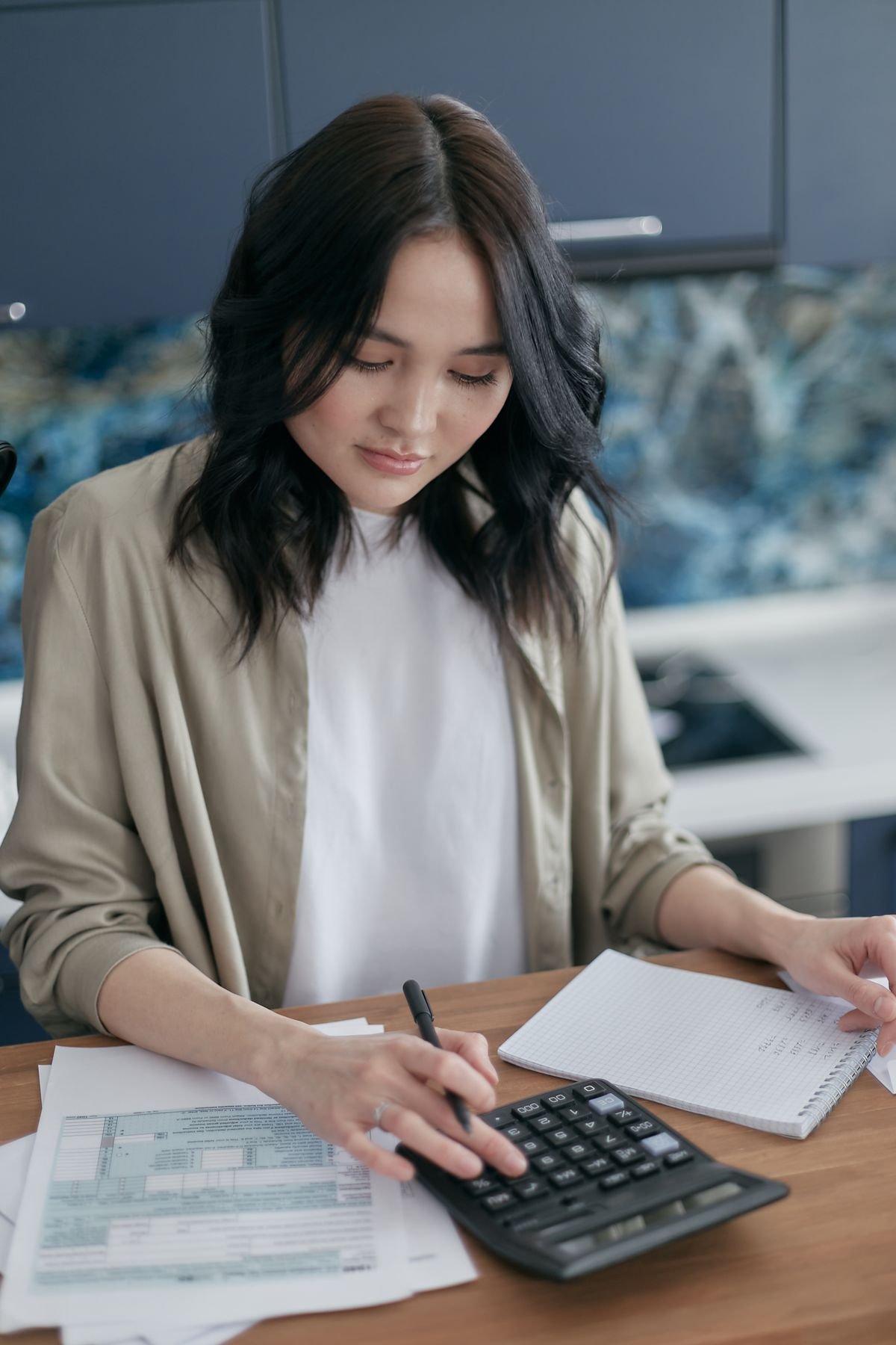 Employee reviewing an itemised pay slip and calculating figures at a desk in Singapore